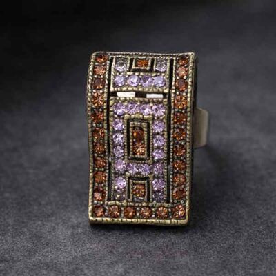 Anillo Onda Áurea de cristal Swarovski marrón y lila sobre fondo gris