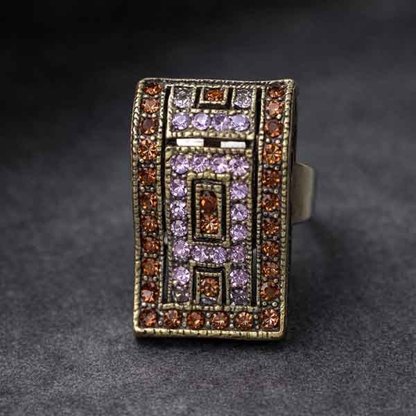Anillo Onda Áurea de cristal Swarovski marrón y lila sobre fondo gris