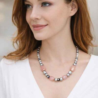 Modelo llevando collar artesanal de cuarzo rosa y perlas grises plata