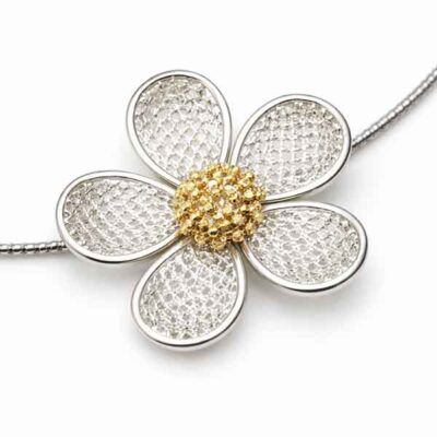 Detalle de flor metálica en collar corto con flores de metal plata y oro
