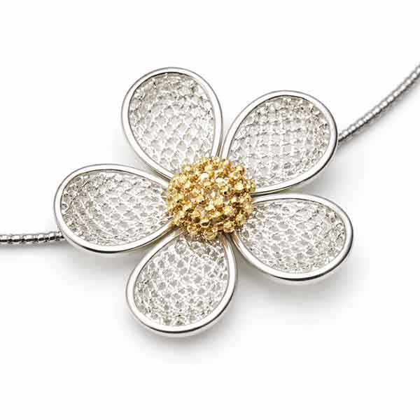 Detalle de flor metálica en collar corto con flores de metal plata y oro