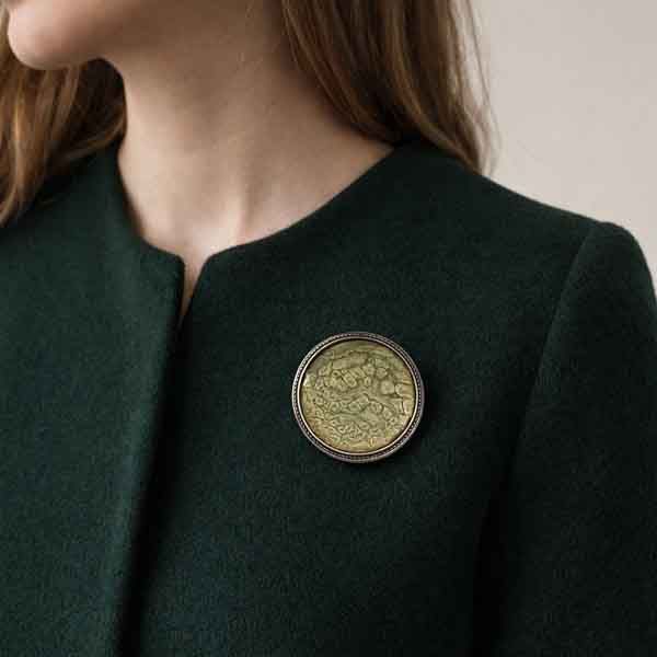 Broche artesanal único Camafeo Tierra sobre abrigo verde oscuro sin solapa