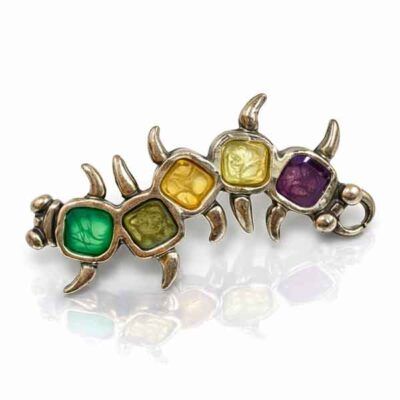 Broche artesanal único Amaro con esmaltes en tonos verde, amarillo, ámbar y morado sobre base metálica