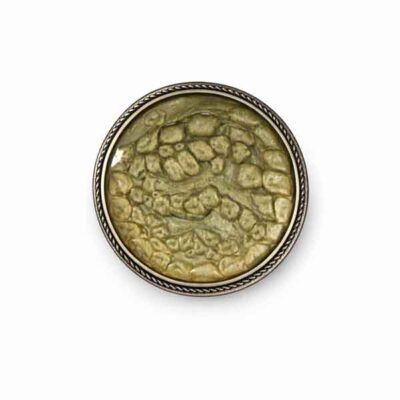 Broche redondo artesanal en tonos oliva y dorado con textura orgánica y marco metálico plateado