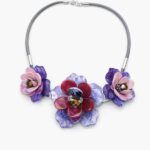 Collar flores moradas y rosas de resina sobre fondo blanco