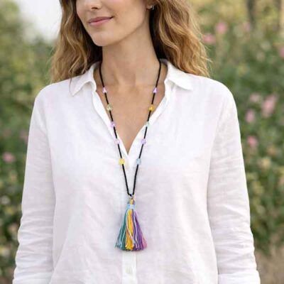 Collar largo con borla multicolor de rocalla negra llevado por modelo, diseño artesanal de 90 cm