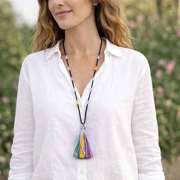 Collar largo con borla multicolor de rocalla negra llevado por modelo, diseño artesanal de 90 cm