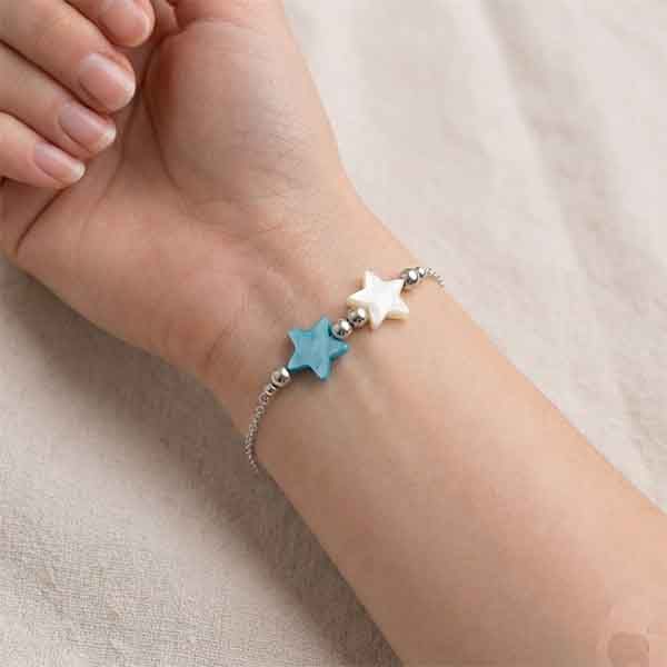 Pulsera de plata de ley con estrellas de nácar azul y blanca puesta en la muñeca
