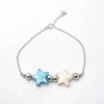 Pulsera de plata con estrellas de nácar azul y blanca sobre fondo blanco
