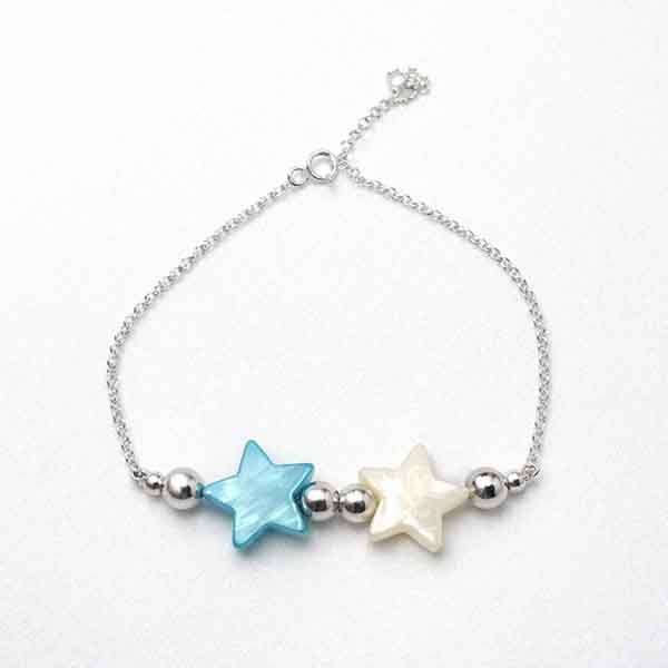 Pulsera de plata de ley con estrellas de nácar Pulsera de plata con estrellas de nácar azul y blanca sobre fondo blanco