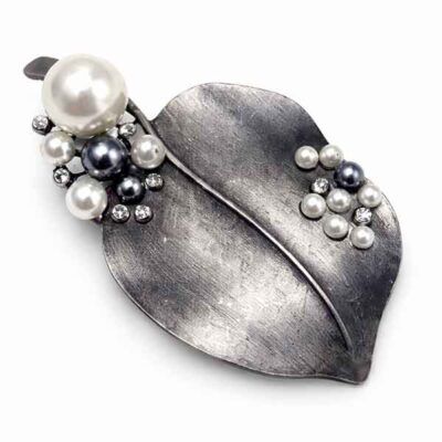 Broche de hoja en plata vieja con perlas en tonos gris y blanco sobre fondo claro