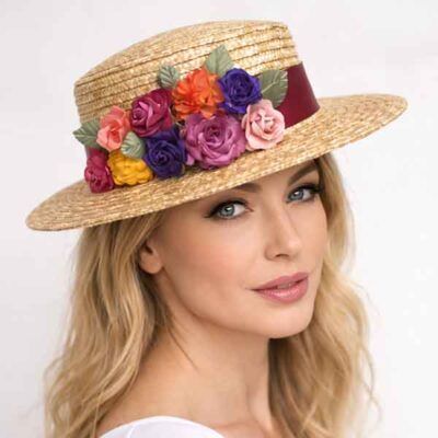 Canotier de paja con flores multicolor artesanales colocado sobre modelo, tocado elegante para eventos y celebraciones