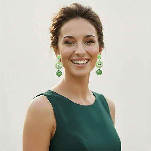 Modelo luciendo pendientes Gabriela artesanales verdes hechos a mano con bola trenzada