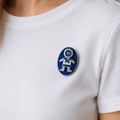 Broche Ejeánico con cristal pintado a mano sobre camiseta blanca. Diseño artesanal de Turquesa y Más inspirado en Ejea de los Caballeros.