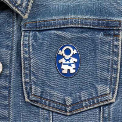 Broche Ejeánica pintado a mano colocado en el bolsillo de una cazadora vaquera azul.