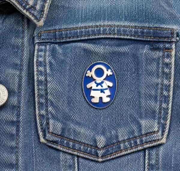 Broche Ejeánica pintado a mano colocado en el bolsillo de una cazadora vaquera azul.