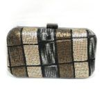 Bolso de fiesta rígido en tonos dorado y negro con diseño geométrico y cierre metálico