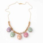Collar multicolor pastel Daira puesto en modelo con cadena dorada