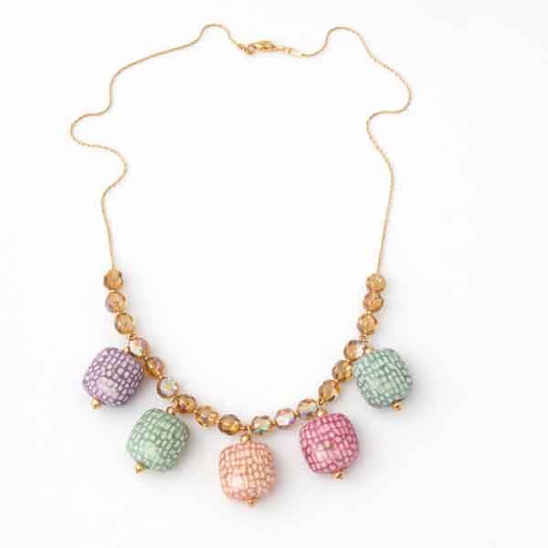 Collar multicolor pastel Daira puesto en modelo con cadena dorada
