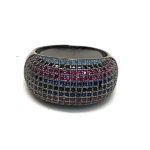 Anillo ancho en plata de ley con circonitas en negro, fucsia y azul, diseño moderno y elegante.