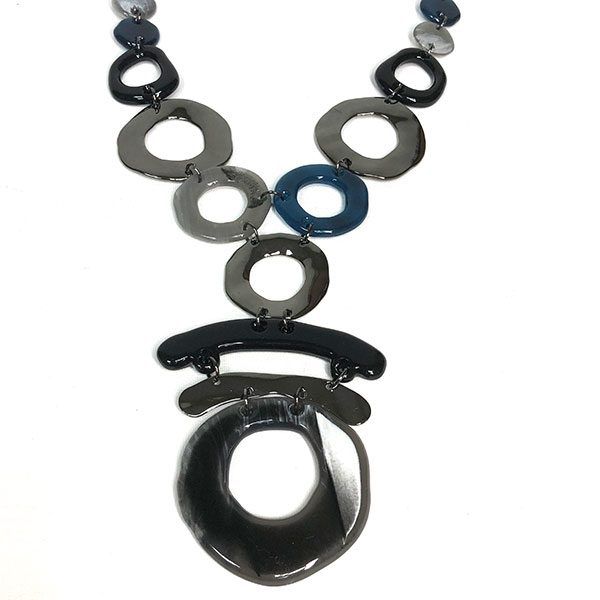 Collar Darcy de resina tipo carey negro y azul con piezas circulares y eslabones en plata vieja, diseño moderno y elegante de bisutería para mujer.
