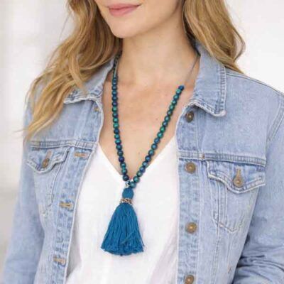 Collar Irati largo con bolas de madera azul y borla, llevado por modelo