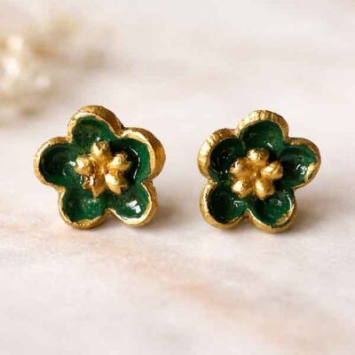 Detalle de pendientes de porcelana pintados a mano en color verde con forma de flor, joya artesanal.