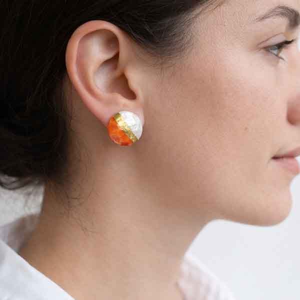 Pendientes de porcelana artesanal Aura Mandarina colocados en la oreja