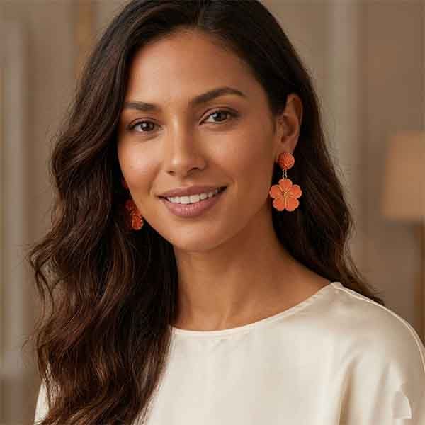 Modelo luciendo pendientes Flor Tahiti artesanales en arcilla polimérica color coral