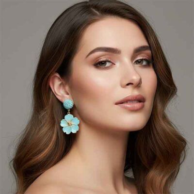 Modelo luciendo pendientes Flor Tahiti artesanales en arcilla polimérica color turquesa