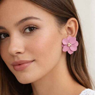 Pendientes Teide de bisutería en forma de flor rosa con perlitas, puestos en modelo