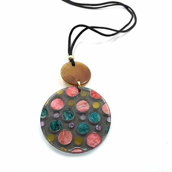 Collar Piruleta de resina con cordón negrones Collar Piruleta de resina con cordón negro y medallón gris con topos de colores en tonos rosa, turquesa y dorado.