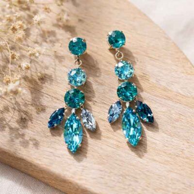 Pendientes de plata con cristal Swarovski turquesa Krisha sobre fondo de madera