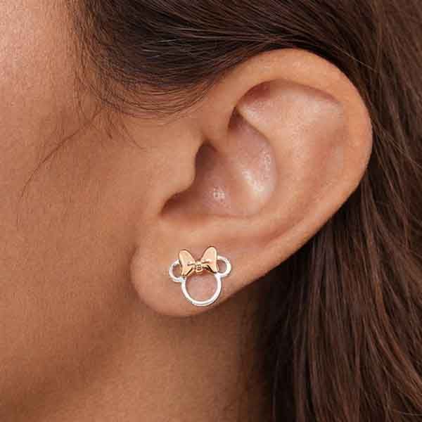 Pendientes Disney Minnie en plata de ley con lazo rosa llevados por mujer