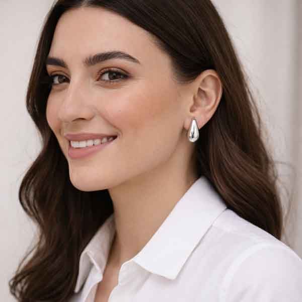 Pendientes Goittia plateados lucidos por modelo con camisa blanca
