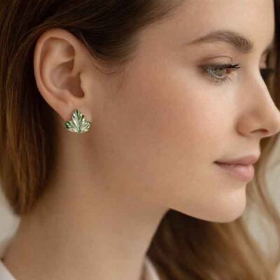 Pendientes de porcelana artesanal en forma de hoja verde puestos en modelo