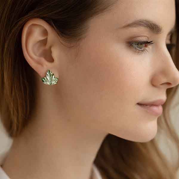 Pendientes de porcelana artesanal en forma de hoja verde puestos en modelo