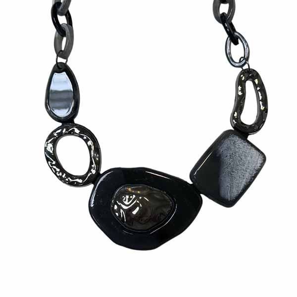 Collar Edelmira corto con eslabones grandes en tonos negros y plateados, con piezas geométricas modernas y acabado brillante.
