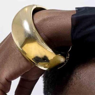 modelo luciendo pulsera ancha dorada Lidun con acabado en oro amarillo de 18k – joya de la línea África de Luxenter