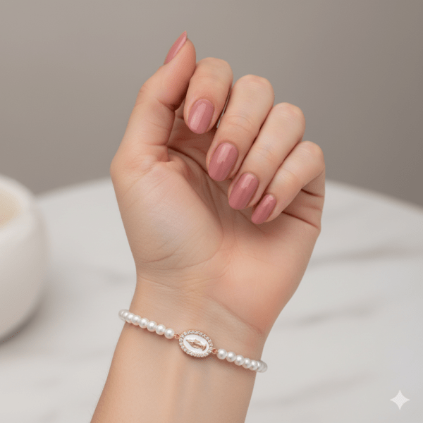 Pulsera de perlas con medalla Milagrosa dorada en la muñeca de una modelo