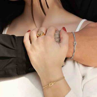 Pareja abrazada luciendo pulseras Nudo de Amor en plata y oro