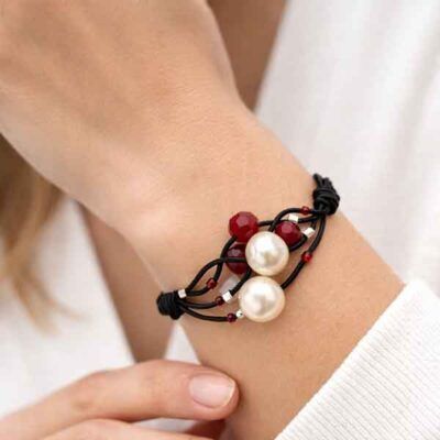 Pulsera Atenea artesanal con perlas y cuentas rojas hecha a mano en muñeca