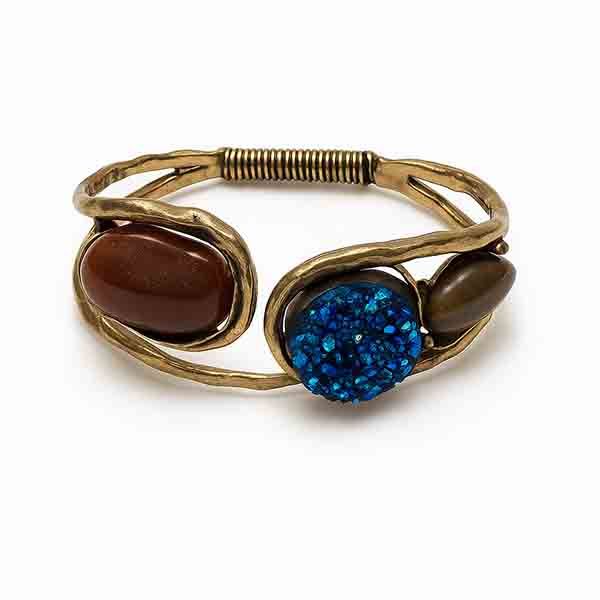 Pulsera Thalassa con piedras naturales Pulsera Thalassa con piedras naturales en azul y marrón sobre metal dorado envejecido, inspirada en la fuerza del mar y la tierra.
