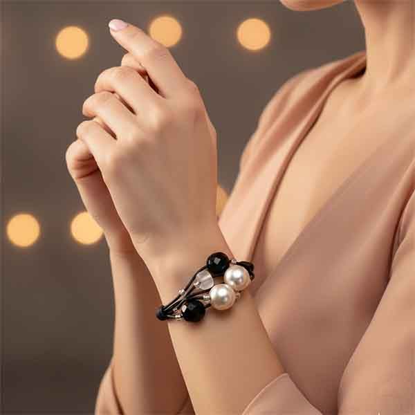 Pulsera Atenea artesanal con perlas y cuentas negras hecha a mano en muñeca