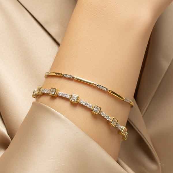 Modelo luciendo la pulsera Welco de plata y circonita brillante con acabado oro amarillo de 18k