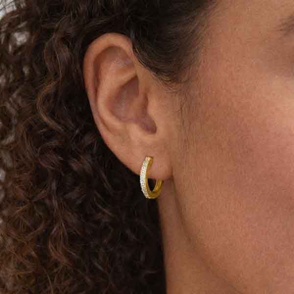 Aros Valarys de oro amarillo con circonitas brillantes puestos en oreja