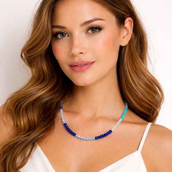 Collar de cristal azul degradado sobre modelo, diseño artesanal con cuentas facetadas y cierre con cadena alargadora