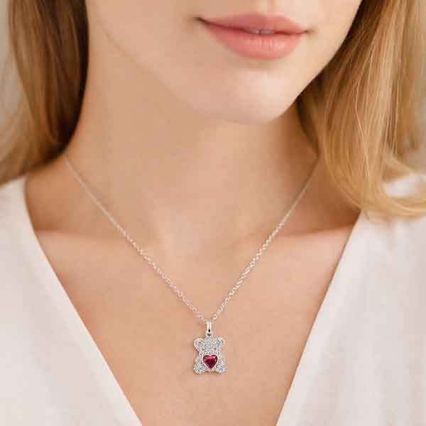 Modelo llevando collar osito de plata con circonitas y corazón rojo