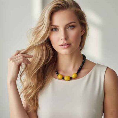 modelo con collar negro y bolas mostaza pieza única artesanal