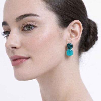 Modelo luciendo pendientes Myrna en rodio con cristal turquesa